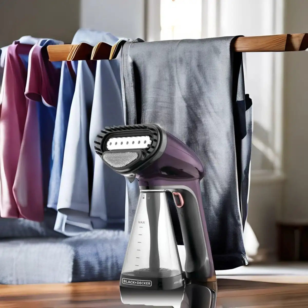 Handheld steamer on a wooden surface with clothes hanging in the background