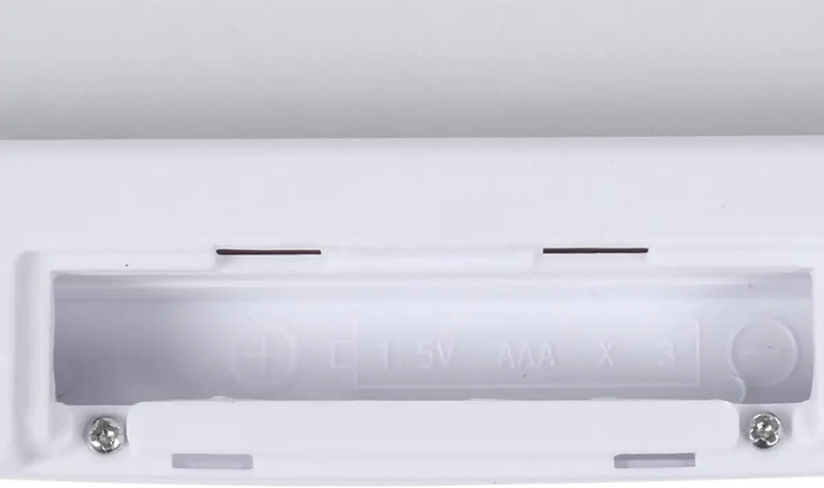 Close-up of a white electronic device with metallic components on a white background