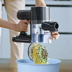 Person using a handheld vacuum cleaner with a brush attachment to clean a sunflower head.