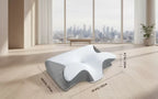 Ergonomic pillow with dimensions displayed on a wooden floor with a cityscape view.