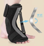 Black foot orthosis with adjustable strap on a beige background
